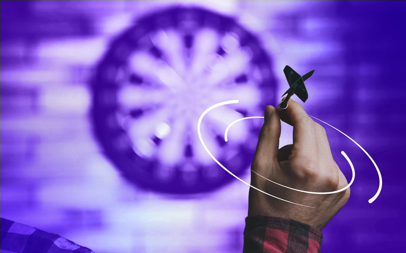 Hand holding dart aiming at target